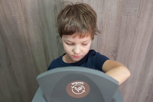 Child boy throwing prganic item to waste bin for orgnic at home. Education about waste segregation concept