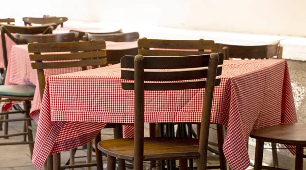 The outdoor cafe tables and chairs with a red tablecloth