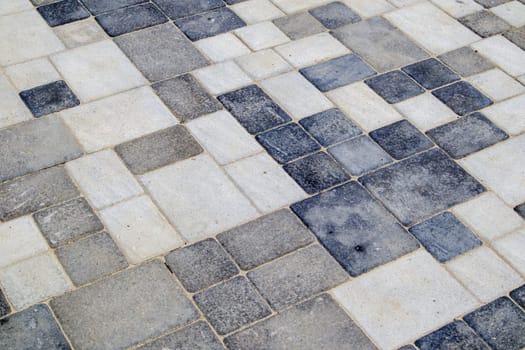 Concrete or paved newly laid gray paving slabs or stones for floors or walkways. Concrete paving slabs in the backyard or road paving. Garden brick path in the courtyard on a sandy foundation