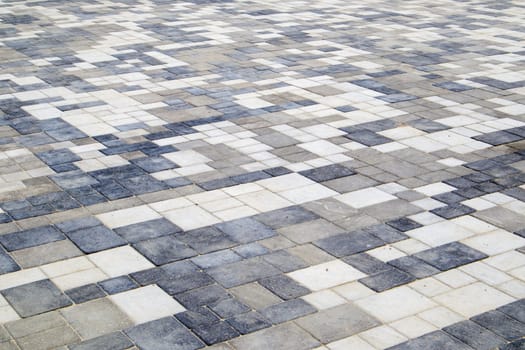 Concrete or paved newly laid gray paving slabs or stones for floors or walkways. Concrete paving slabs in the backyard or road paving. Garden brick path in the courtyard on a sandy foundation