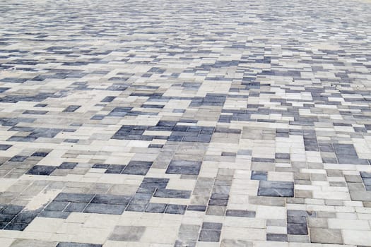 Concrete or paved newly laid gray paving slabs or stones for floors or walkways. Concrete paving slabs in the backyard or road paving. Garden brick path in the courtyard on a sandy foundation