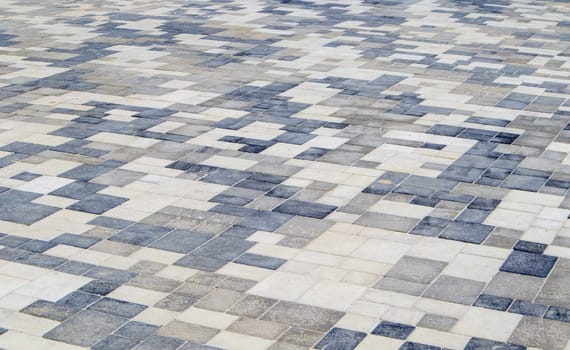 Concrete or paved newly laid gray paving slabs or stones for floors or walkways. Concrete paving slabs in the backyard or road paving. Garden brick path in the courtyard on a sandy foundation