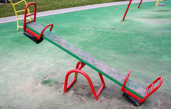 Closed modern playground. Security and protection measures against COVID-19 in the city park. Children's empty swing balancer in the park without people. The concept of childhood is over