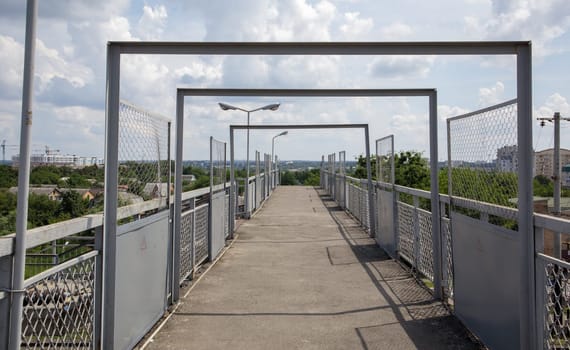 Railway bridge with steps, with impressive steps in perspective. Overhead pedestrian crossing. Bridge stairs connecting one platform to another at the train station