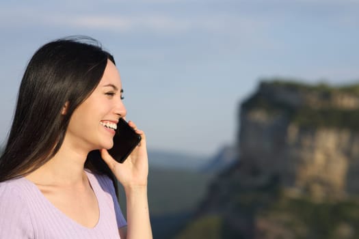 Asian woman talking on phone in the mountain