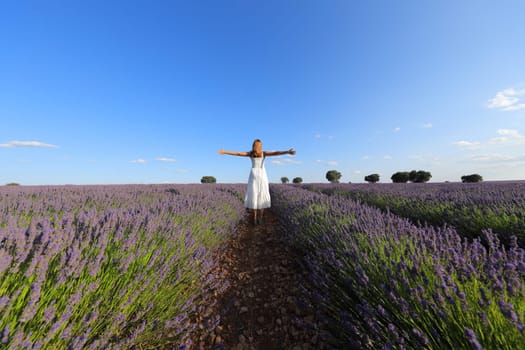 Woman celebrating outstretching arms in a lavender field