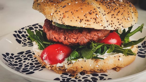 Close-up shot of vegan or plant based hamburger with lettuce tomato and vegenaise in burger bun