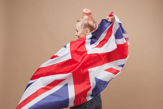 Young caucasian hipster woman with flag of Great Britain. Studio shot