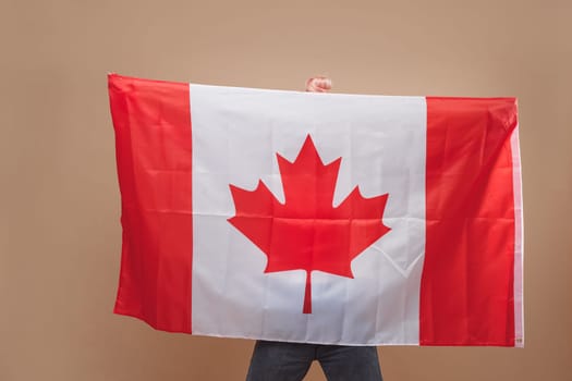 Beautiful asian woman, a sports fan, standing in front of a Canadian flag