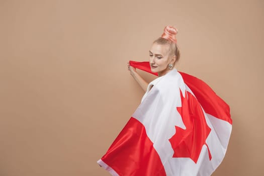 Beautiful asian woman, a sports fan, standing in front of a Canadian flag