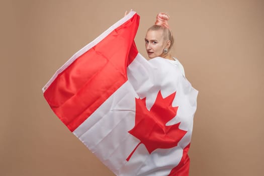 Beautiful asian woman, a sports fan, standing in front of a Canadian flag