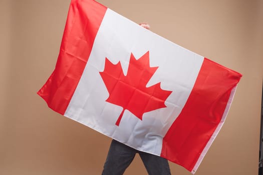 Beautiful asian woman, a sports fan, standing in front of a Canadian flag