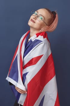 Young woman expat in eyeglasses with great britain flag. Studio shot. English language hipster teacher. Fashionly dressed woman with pink hairs in black leaher jacket and white blouse. Autumn style