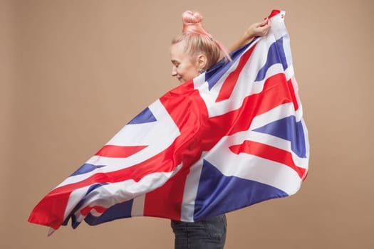 Young caucasian hipster woman with flag of Great Britain. Studio shot