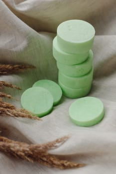 Stack of assorted natural soap bars with lavender on linen textile cloth. Pastel colors