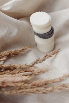 Stack of assorted natural soap bars with lavender on linen textile cloth. Pastel colors