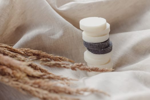 Stack of assorted natural soap bars with lavender on linen textile cloth. Pastel colors