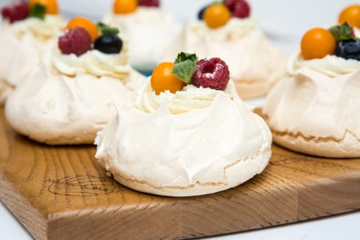 Pavlov's cake. Cakes on a platter. Sweet Dessert. A treat for the guests. Dessert for the holiday. The cake is decorated with berries
