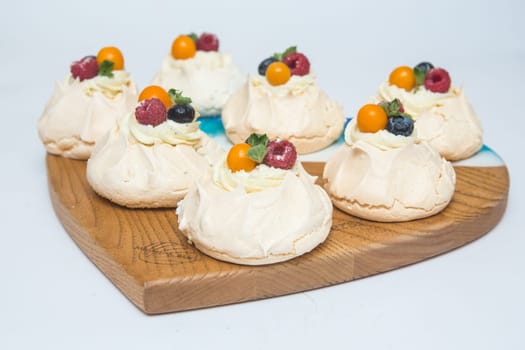 Pavlov's cake. Cakes on a platter. Sweet Dessert. A treat for the guests. Dessert for the holiday. The cake is decorated with berries