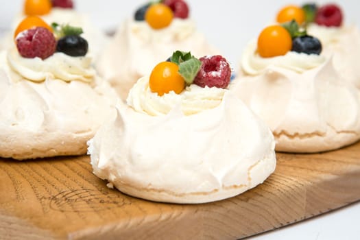 Pavlov's cake. Cakes on a platter. Sweet Dessert. A treat for the guests. Dessert for the holiday. The cake is decorated with berries