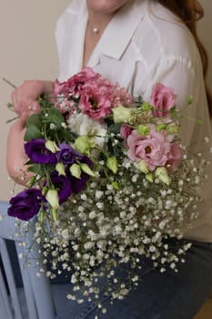 a girl or a woman holds a bouquet of small flowers.