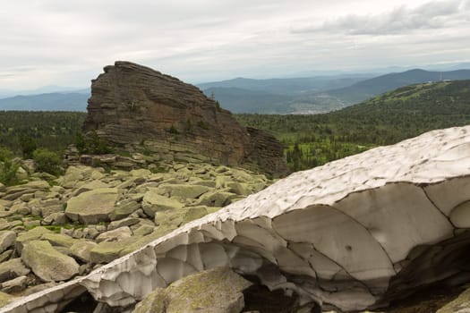 large kurum stones lie in the forest in the mountains, stones covered with moss, against the background of the forest, mountain landscape, high in the mountains..