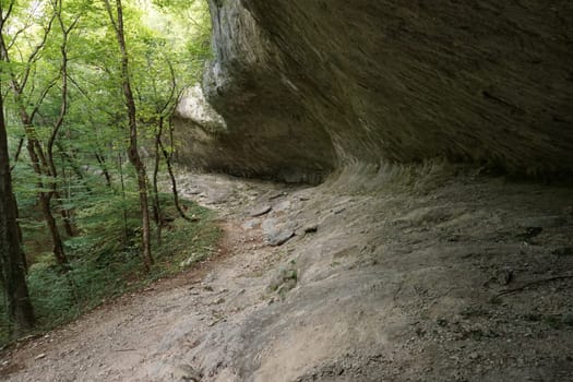 Walking under giant stone structure on the way to Bijela Canyon, 2020