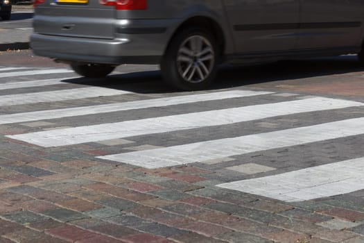 An empty pedestrian crossing and a car on it