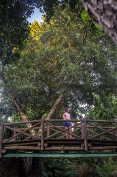 Child girl over The world shortest international bridge of El Marco. La Codosera district, Extremadura, Spain