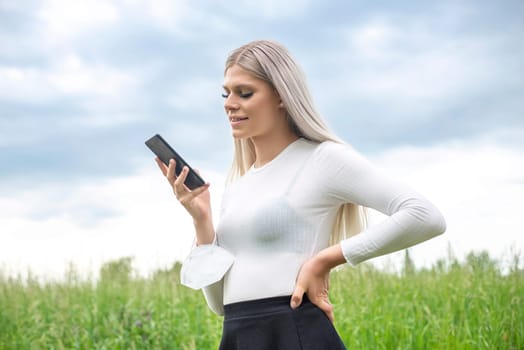 happy young woman with smartphone and mask