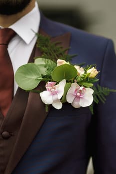 Groom's cBoutonniere on the groom's jacket of their orchids orsage - Flower Arrangement, orchid, rose