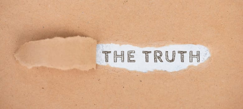 The words the truth standing on a ripped up paper