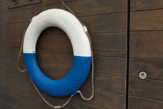 white and blue lifebuoy on board a ship close-up