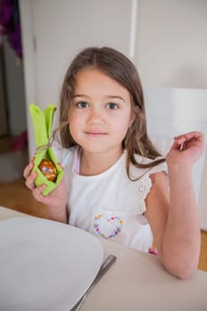 Portrait of adorable little girl with colorful Easter eggs at home, Holiday day