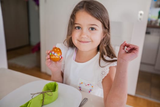 Portrait of adorable little girl with colorful Easter eggs at home, Holiday day