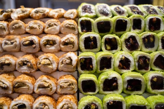rows of assorted Turkish delight sweets desserts with dried fruits lined up in the store window