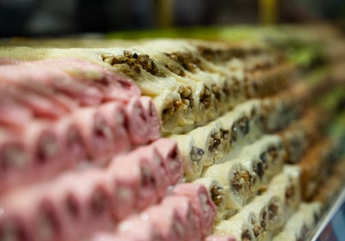rows of Turkish delight sweets desserts with dried fruits lined up in the store window