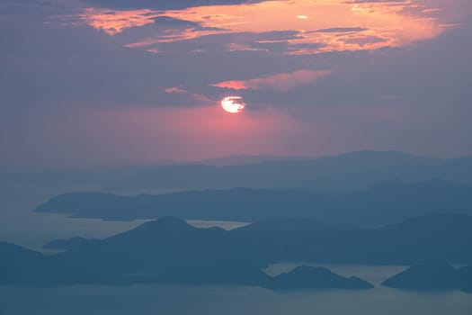 beautiful aerial panorama from the Babadag peak of high mountains rising up over the Mediterranean sea at sunset near Oludeniz Blue Lagoon coast in Turkey during summer