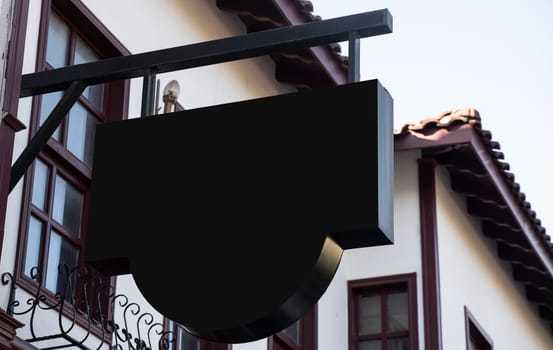 Horizontal front view of empty round black signage on a building with classical rustic architecture