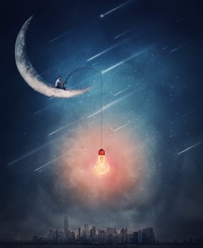 Surreal scene over the night city with a creative boy seated on the crescent moon using a fishing rod with a light bulb as a bait for catching new ideas. Magical adventure concept