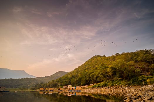 Panorama View of tropical lake and mountains. Small bamboo traditional cottage next the lake in Sukhothai Thailand