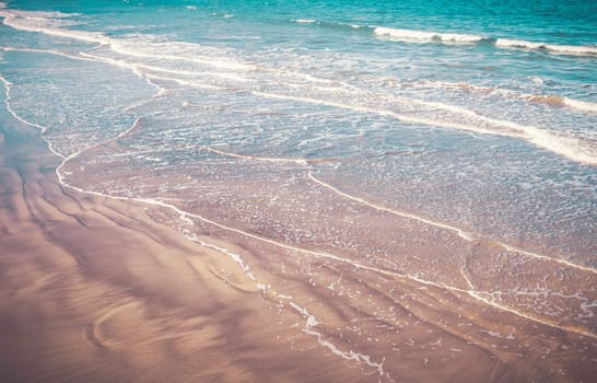 waves washing ashore on the washed-out sand seen from above in Brittany