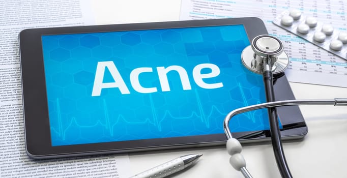 The word Acne on the display of a tablet