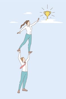 Teamwork, business achievement and success concept. Young smiling businessman holding business woman colleague on raised hands reaching for golden trophy meaning success and achievement