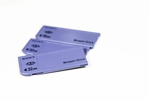 Rome, Italy, August 2021: three Sony Memory Stick cards of different capacities stacked on a white background. Storage and saving of data.