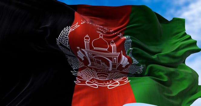 Flag of Islamic Republic of Afghanistan waving in the wind. National flag waving. Vertical stripes with the design of a white mosque and wheat