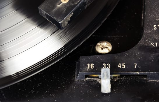 black vinyl record spinning on the turntable with the speed selector set to 33 rpm. Vintage audio equipment. Vinyl record player