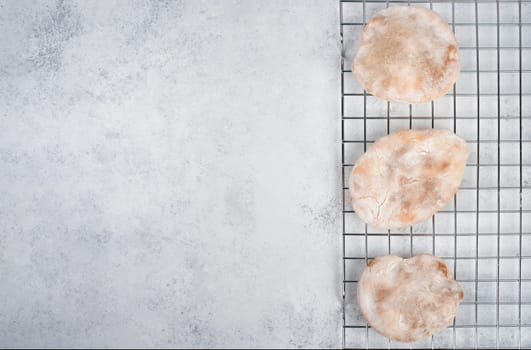 Fresh baked pita bread on a colling grid, empty copy space for text