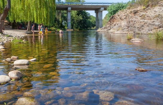 Swimmers enjoy Abadia natural swimming pool area. Caceres, Extremadura, Spain