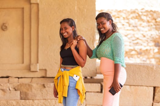AXUM, ETHIOPIA, APRIL 27th.2019: Ordinary carefree tigray native girls walking on the street in center of Aksum on April 27, 2019 in Aksum, Tigray, Ethiopia Africa